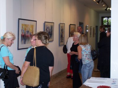 zu sehen sind Besucher einer Bilderausstellung im Rathaus Bous