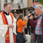 zu sehen ist Moderator Thomas Wollscheid im Interview mit Pastor Dr. Frank Kleinjohann. Im Hintergrund das Filmteam des Saarländischen Rundfunks