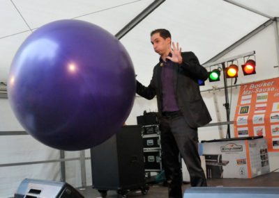 zu sehen ist der Zauberer Maxime Maurice auf der Maisausenbühne mit einem riesigen Ballon