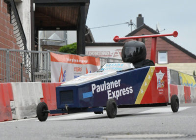 zu sehen ist die Seifenkiste der Bayern-Bazis-Bous im Rennen an der Bouser Maisause, die Kiste trägt den Namen Paulaner Express