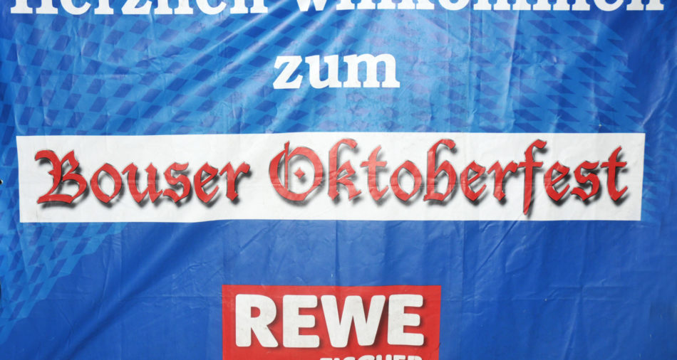 zu sehen ist ein Banner mit dem Aufdruck Herzlich Willkommen zum Bouser Oktoberfest wuenscht REWE Fischer