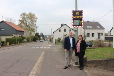 zu sehen sind Buergermeister Stefan Louis und die Leiterin der Ortspolizeibehoerde Birgit Laschet vor der Geschwindigkeitsmessanlage in der Griesborner Straße